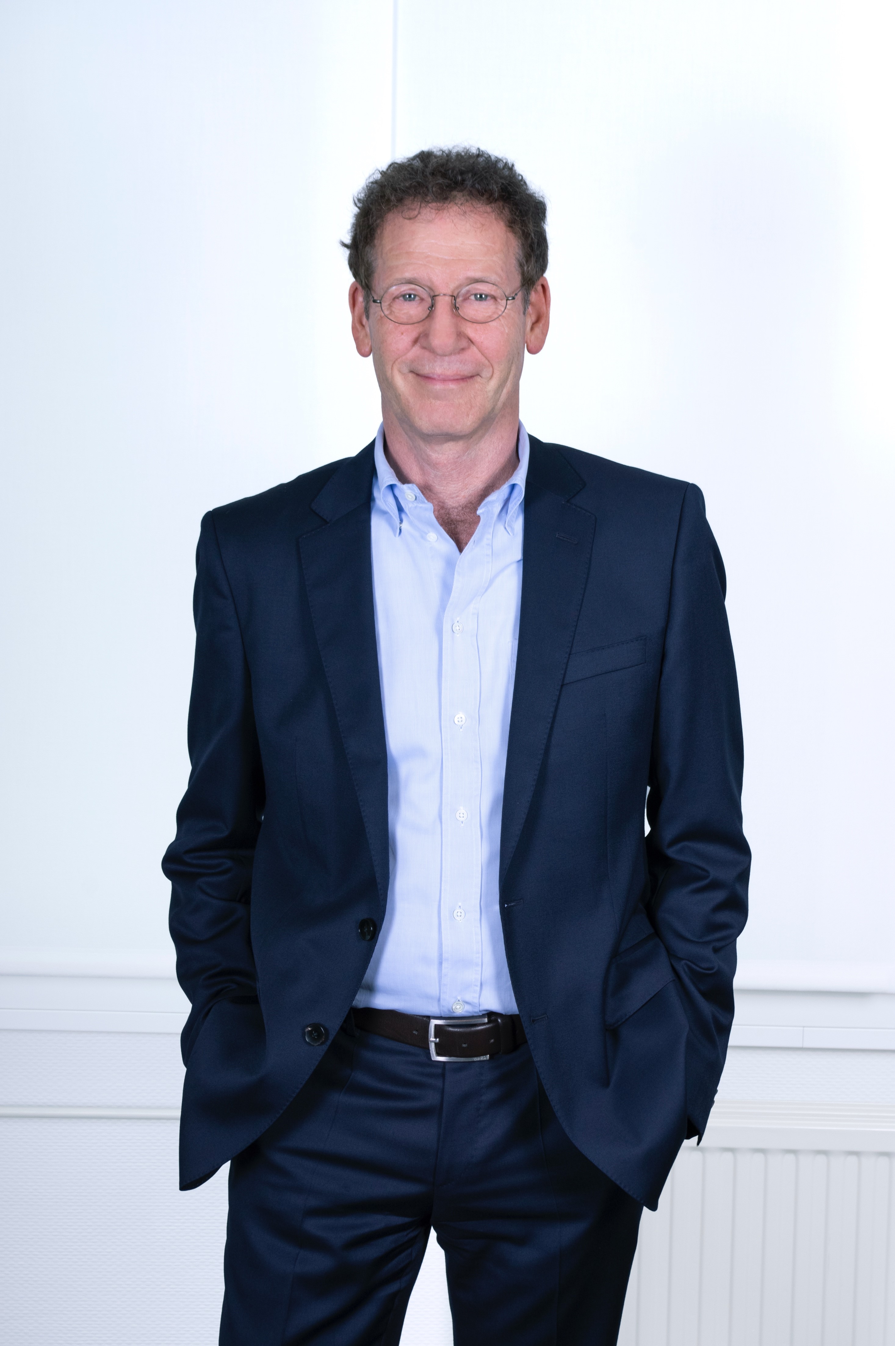 Foto von Wolfgang Kallweit, Geschäftsführender Gesellschafter von PropertyExpert, lächelnd im Anzug, mit den Händen in den Hosentaschen